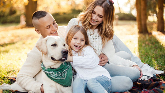 Famiglia felice con cane Labrador in parco autunnale, benessere animale e momenti di vita con il proprio pet